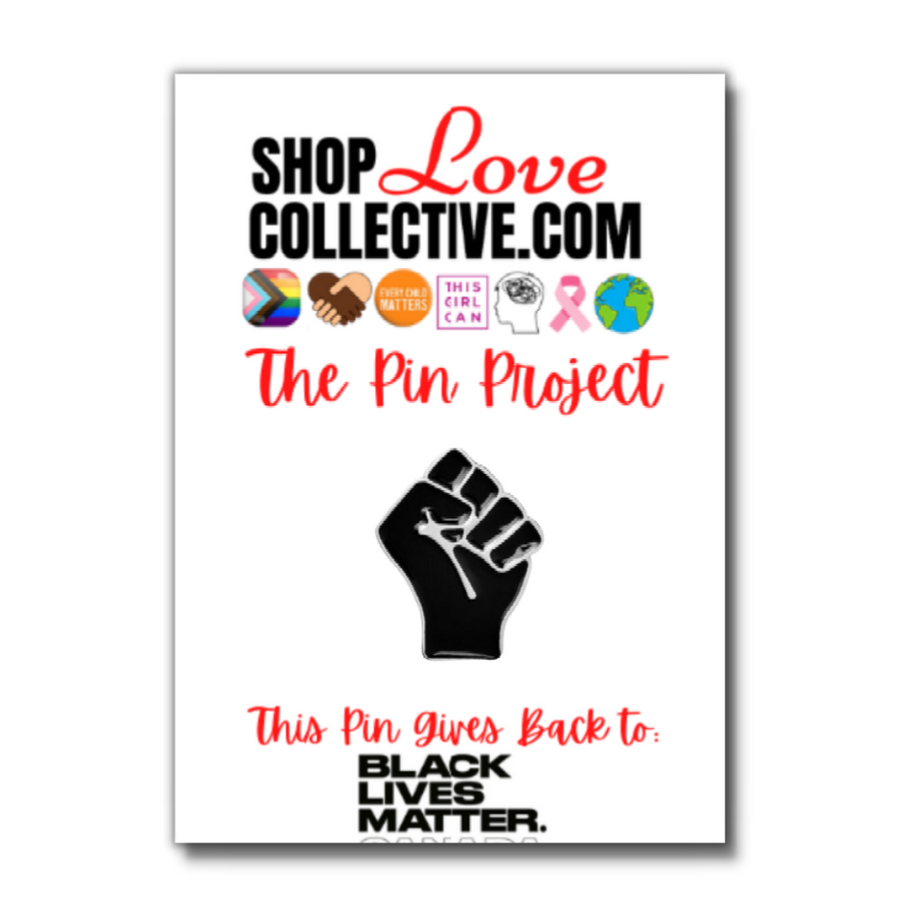 An enamel pin in the shape of a raised black fist, is mounted on a cardstock reading "Shop Love Collective .com, The Pin Project."  Directly below that are several symbols including the Progress Pride Flag, white & brown hands holding in the shape of a heart, the words "every child matters" in an orange circle, and more.  At the bottom of the cardstock  it says "This pin gives back to Black Lives Matter Canada."